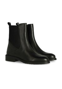 Botas de tobillo de cuero negro con paneles laterales elásticos, detalles de brogue en la puntera y un tacón bajo. Textura suave y suela resistente.