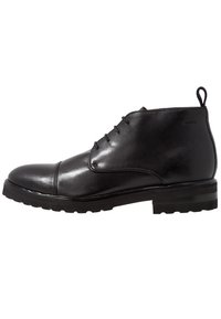 Stivaletto in pelle nera con lacci frontali, linguetta sul tallone e suola testurizzata, progettato per un abbigliamento formale o smart-casual.