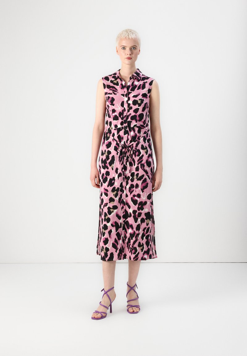 Ροζ φόρεμα με λεοπάρ μοτίβο, χωρίς μανίκια, με κουμπωτή μπροστινή όψη, δεμένο στη μέση και μήκους midi, συνδυασμένο με μωβ ψηλοτάκουνα σανδάλια με λουράκια.