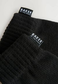 Zwei schwarze Strickmützen liegen übereinander, jede mit einem Etikett, das "BAKER by Ted Baker" zeigt. Die Textur wirkt weich und warm.