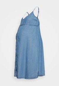 Vestido de maternidade em denim com alças finas, corpete ajustado e saia rodada. Apresenta botões na frente e uma cor azul clara.