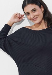 Schwarzes, geripptes Strickoberteil mit schulterfreiem Schnitt, weiten Ärmeln und strukturiertem Stoff, bietet eine lockere Passform und eine weiche Oberfläche.