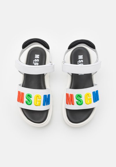 Des sandales blanches avec des semelles noires, ornées d'un audacieux "MSGM" brodé multicolore sur la bride avant. Brides de cheville réglables incluses.