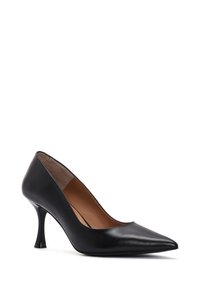 Zapato de tacón alto de cuero negro con punta afilada y un diseño de tacón curvado único. Textura suave con un acabado mate y forro interior beige.