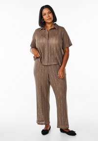 Bruine gebreide twee-delige outfit met een kortgebouwde coll shirt en wijde broek met een gestructureerd ruitpatroon.