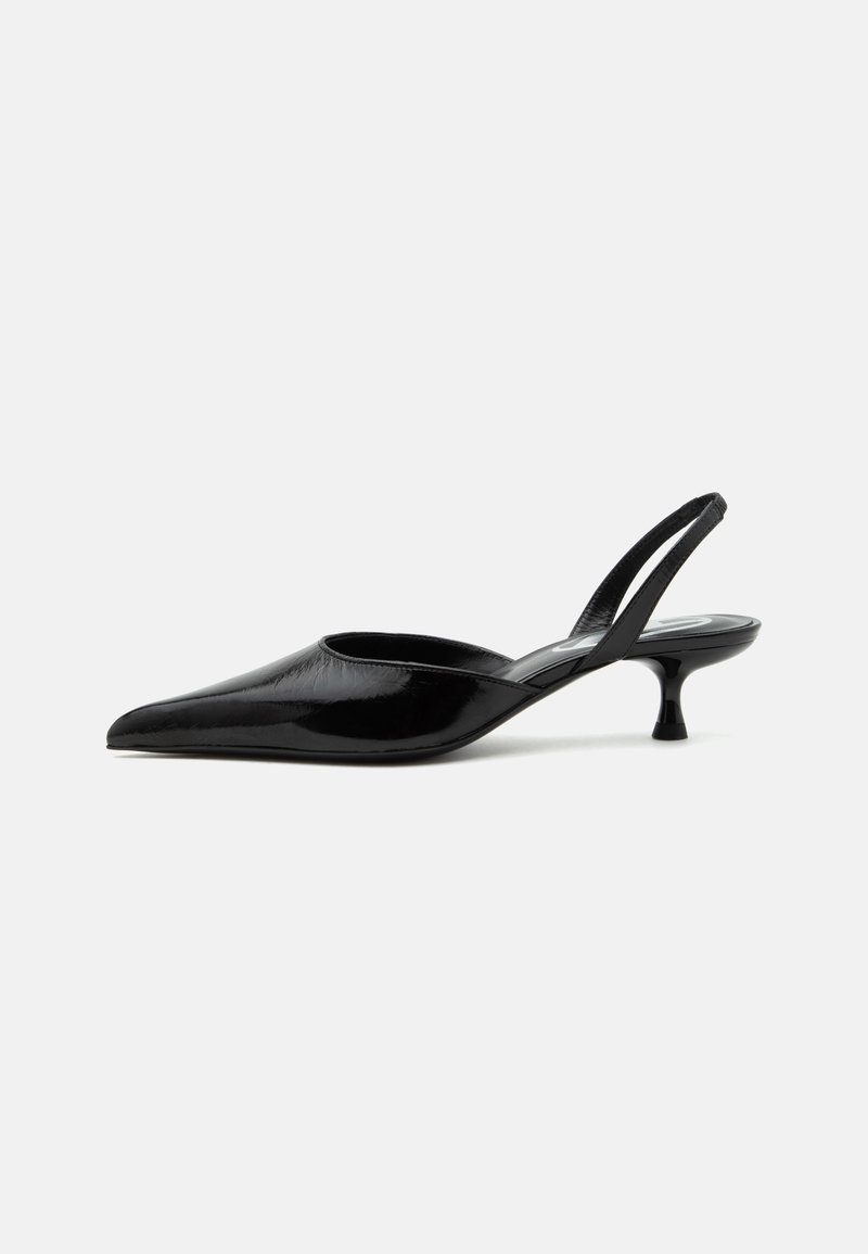 Μαύρο παπούτσι slingback kitten heel από λευκό δέρμα με μυτερή μύτη και χαμηλή καμπυλωτή τακούνι σε απλό ανοιχτό φόντο.