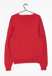 Pull en tricot rouge à coupe décontractée, col rond, poignets et ourlet côtelés. Présente une texture unie et des coutures d'épaule tombantes.