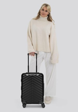 Schwarzer Hartschalenkoffer mit einem Zickzackmuster, ausziehbarem Griff und vier Rollen. Das Design ist schlank und modern und betont eine kompakte Form.