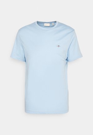 Lyseblå bomull T-skjorte med rund hals, korte ermer, og en liten brodert logo på brystet. Glatt tekstur, standard passform.