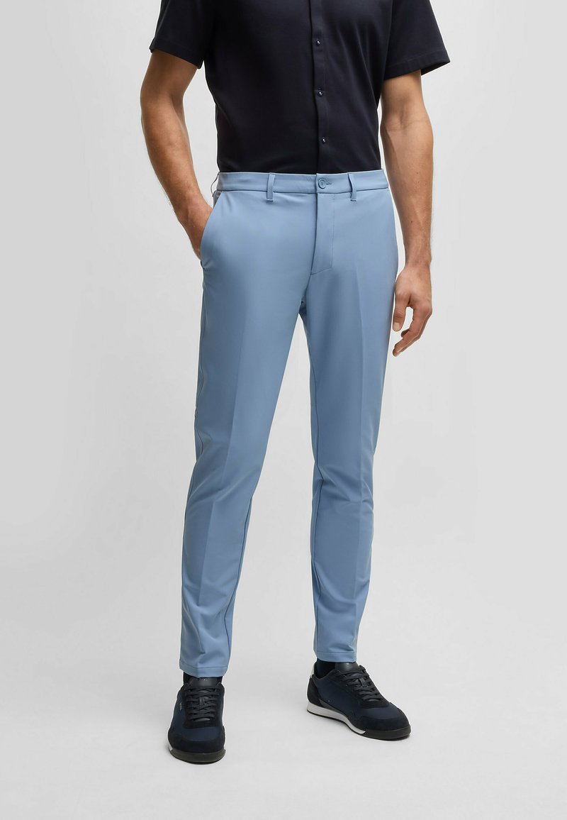 Light blue tailored pants made from a smooth, stretchy fabric. The design features side pockets and a classic zip fly with button closure.