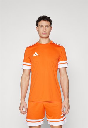 Oranje sportshirt met witte strepen op de mouwen, gecombineerd met bijpassende shorts. Het materiaal lijkt lichtgewicht; heeft een Adidas-logo ontwerp.