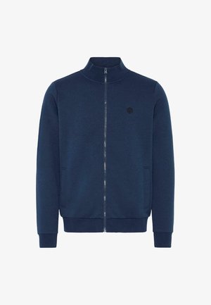 Marineblå zip-up jakke laget av mykt materiale, med høy krage, sidelommer og en liten brodert logo på brystet.