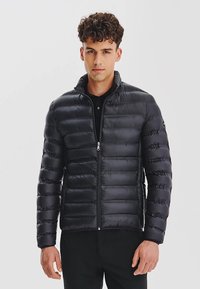 Czarna kurtka puchowa z wysokim kołnierzem, poziomym wzorem pikowania i pełnym zamkiem z przodu. Wykonana z błyszczącego materiału syntetycznego, o lekkiej teksturze.