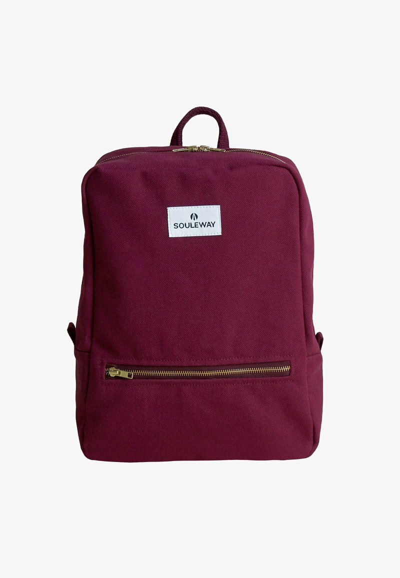 Burgundy ryggsäck med en klassisk design, tillverkad av texturerat tyg. Har en framficka med dragkedja och ett handtag upptill för bärande.
