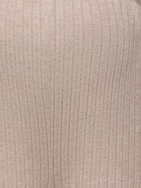 Κοντινό πλάνο μπεζ υφάσματος πλεκτού με ριγέ υφή και κάθετες ριγες σε απαλό ένδυμα.