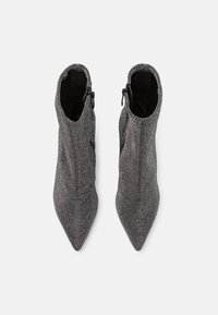 Grå texturerade ankelstövlar med spetsig tå, sidodragkedja och en slät inredning.