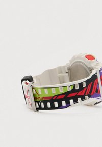 Hvid digital armbåndsur med farverig rem i rød, grøn, sort og lilla grafik, metalspænde og rød knap, vist fra siden.