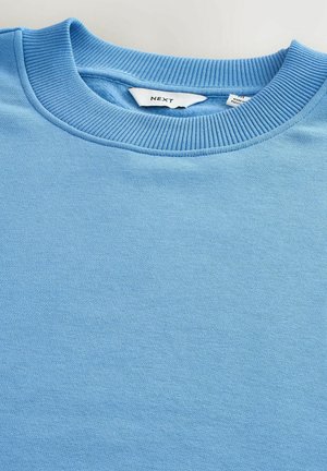 Helles blaues Sweatshirt mit einem gerippten Rundhalsausschnitt. Besitzt eine weiche Textur, ein einfaches Design und ein Etikett mit der Marke "NEXT".