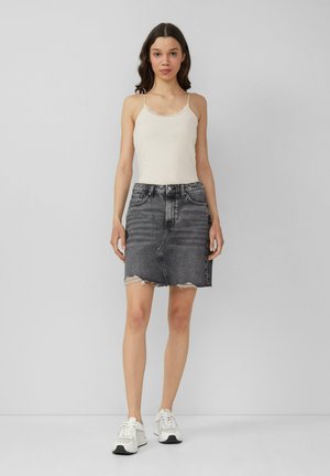 Denim mini skirt in black with frayed hem, featuring a classic five-pocket design and belt loops. Paired with a plain light tank top and white sneakers.