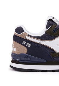 Sneaker navy e verde oliva con materiali in camoscio e mesh, dettagli bianchi e suola texturizzata. Presenta dettagli con "N.92" e logo del marchio.