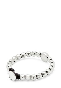 Pulsera de cuentas de metal plateado con un acabado suave, que cuenta con un elástico y un cierre circular. Las cuentas varían en tamaño y están dispuestas de manera uniforme.