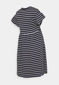 Námořnické modro-bílé pruhované šaty s krátkými volánkovými rukávy a řaseným pasem, vystavené na jednobarevném bílém pozadí.