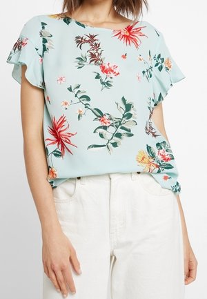 Blusa floreale a maniche corte in tessuto azzurro chiaro, con vivaci motivi di fiori rossi, gialli e verdi. Leggera e dalla vestibilità rilassata.