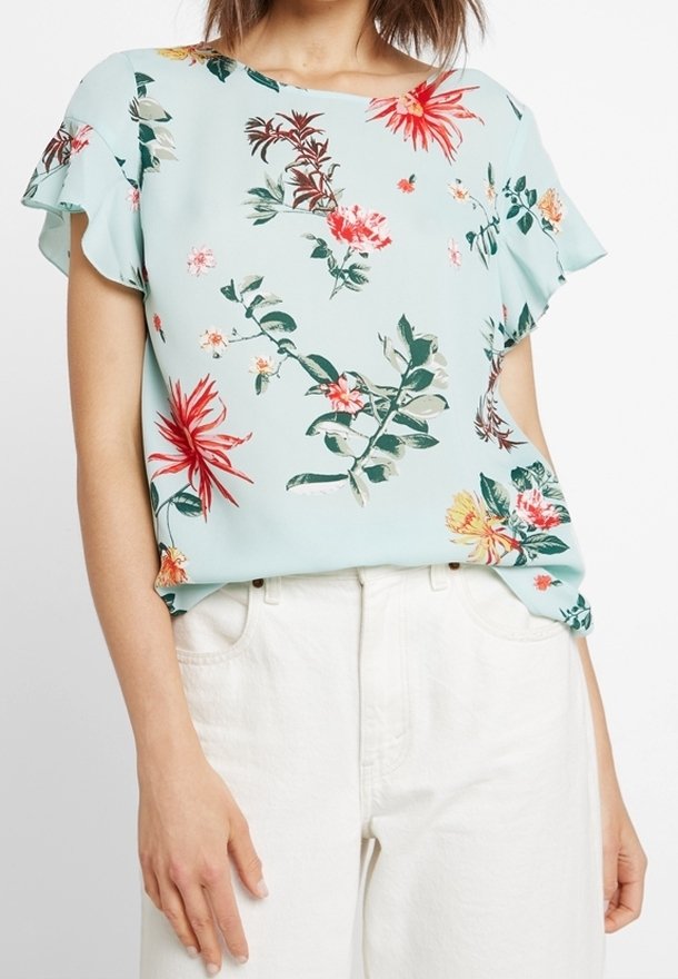 Květinová blůza s krátkým rukávem ze světle modré látky, s živými vzory červených, žlutých a zelených květin. Lehké provedení a volný střih.