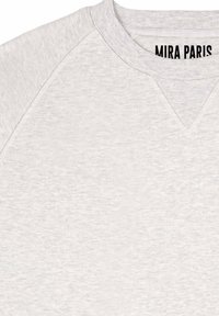 Felpa grigio chiaro con scollo a V, tessuto strutturato e maniche raglan. Presenta l'etichetta 'MIRA PARIS' sul collo.
