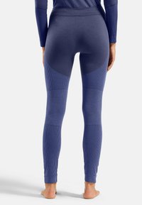 Marineblaue Leggings mit strukturiertem Rippdesign, ausgestattet mit einem hohen Bund und farblich abgesetzten Akzenten in helleren Tönen. Nahtloses Design an den Knöcheln.