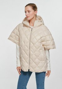 Padded, beżowa pikowana kurtka z kapturem, krótkimi rękawami, zamkiem błyskawicznym z przodu i bocznymi kieszeniami. Gładka tekstura i nowoczesna sylwetka.