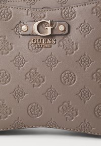 Grijze handtas van geperst leer met een herhalend logopatroon, gouden beslag en een prominent "G"-logo-accent met gestikte details.