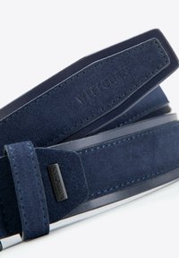 Dunkelblauer Wildledergürtel mit Lederelementen, ausgestattet mit einer gesteppten Kante und einer Logo-Plakette. Glatte Textur und elegantes Design mit klassischer Form.