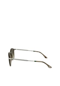 Bruine gradient zonnebril met een transparante kunststof montuur, zilveren metalen armen met een geometrisch patroon en groene accenten op de uiteinden.