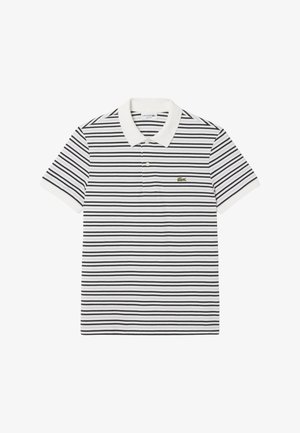 Polo bianca a maniche corte con strisce orizzontali nere, colletto e polsini bianchi, e piccolo logo di coccodrillo verde sul petto sinistro.
