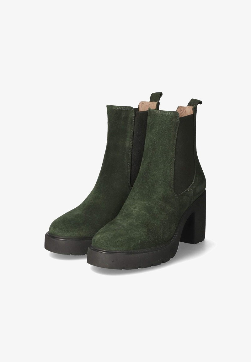 Paire de bottines en daim vert foncé avec talons compensés noirs épais et panneaux latéraux élastiques sur fond blanc.