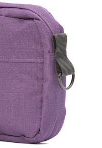 Lila Stofftasche mit strukturierter Oberfläche, ausgestattet mit einem grauen Riemen und einem Metall-D-Ring zur Befestigung. Kompakte rechteckige Form.