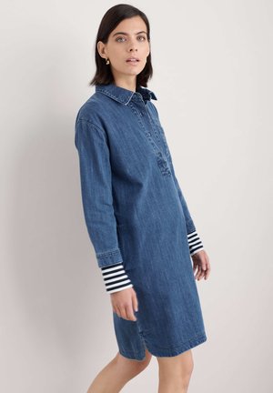 Denimkleid mit Kragen, Vorderknöpfen und langen Ärmeln mit gestreiften Manschetten. Auf leicht über dem Knie geschnitten und mit einem lockeren Schnitt.