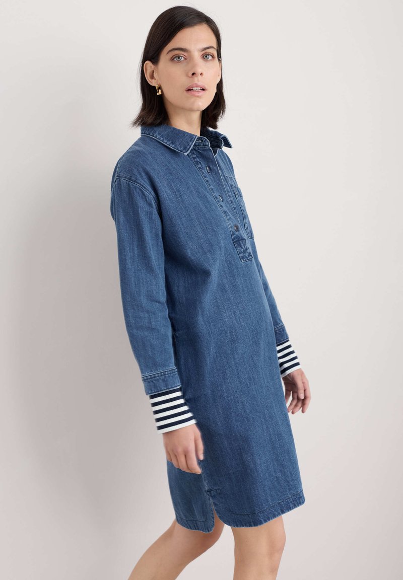 Jeansklänning med krage, framknäppning och långa ärmar med randiga manschetter. Skuren strax ovanför knät med en avslappnad passform.