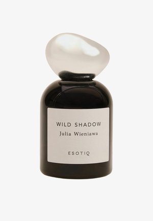 Czarny szklany flakon perfum o zaokrąglonym kształcie, z gładką, owalną białą nakrętką. Etykieta z napisem "WILD SHADOW" oraz "ESOTIQ".