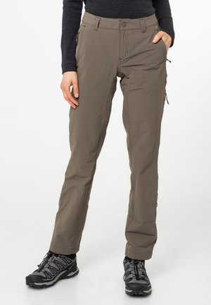 Pantalons de randonnée légers, couleur kaki, avec une texture lisse, poches zippées et bas ajustables ; associés à des chaussures de randonnée robustes noires.