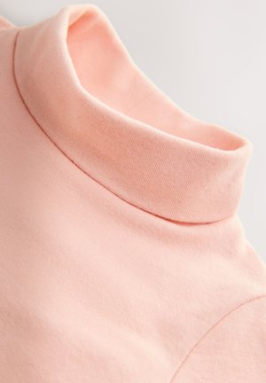 Top rosa in cotone con collo alto, dalla texture morbida, caratterizzato da un colletto arrotolato e dettagli di cuciture sottili. Il tessuto sembra leggero.