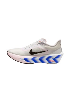 White Nike running shoe with black swoosh, blue chevron patterned thick sole, and orange text on the heel, shown from the side.