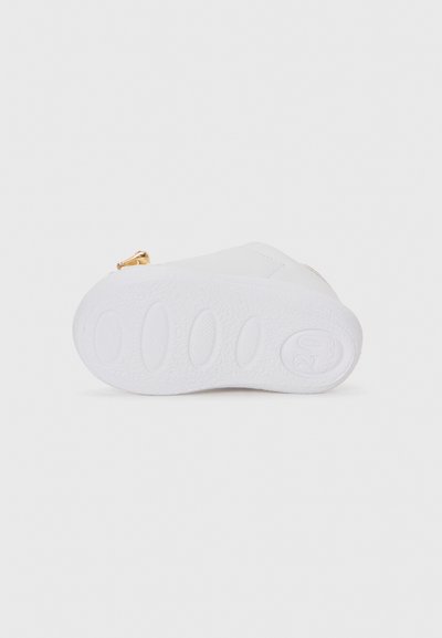 Baskets blanches avec une semelle en caoutchouc texturé de forme ronde et une accent de fermeture éclair. Matériau supérieur en synthétique lisse.