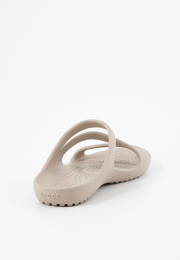 Beżowe klapki z dwoma górnymi paskami, teksturowaną wkładką i wzorzystą podeszwą, wykonane z elastycznego materiału przypominającego gumę.