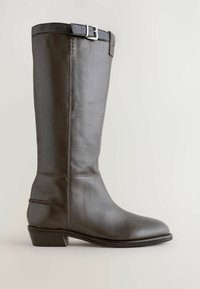Stivale marrone in pelle al ginocchio con un design strutturato, punta rotonda e tacco basso. Presenta una fibbia in argento e dettagli cuciti.