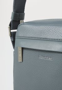 Calvin Klein MUST REPORTER  - Keresztpántos táska - turbulence