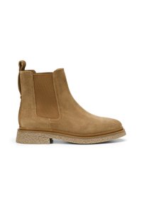 Bottines en daim marron avec des panneaux latéraux élastiques, une semelle en caoutchouc texturée et une languette à l'arrière pour un enfilage facile.