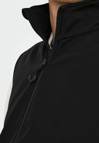 Schwarwest zip-up Weste mit hohem Kragen, die eine glatte Textur und ein minimalistisches Design aufweist. Enthält ein schwarzes Reißverschlussdetail auf der Vorderseite.