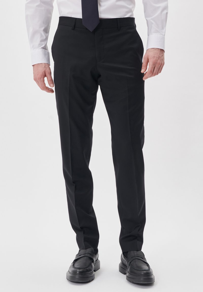 Black dress pants with a tailored fit, made from a smooth fabric. Features a flat front, side pockets, and minimalist design.
